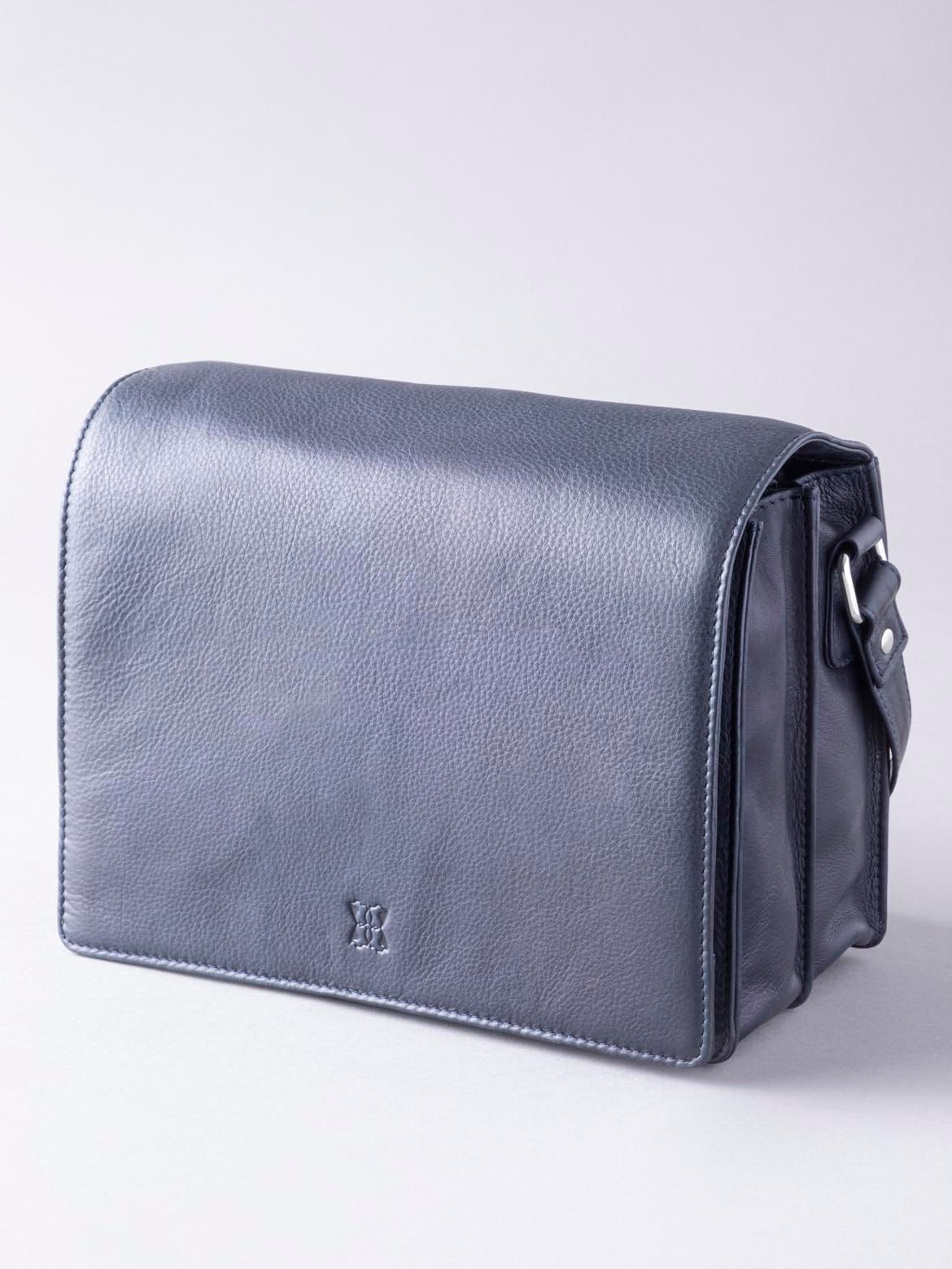 Elegant on the outside and hardworking on the inside, the Ennerdale Leather Organiser Bag in Navy is the perfect work week companion. Embrace this practical yet stylish bag, with pockets for everything from your phone to your cards, and large central compartments for near enough everything else, all neatly housed under the large flapover magnetic design. The long leather and fabric shoulder strap is ideal for slinging over the shoulder or carrying cross body. It's a bag made for business.