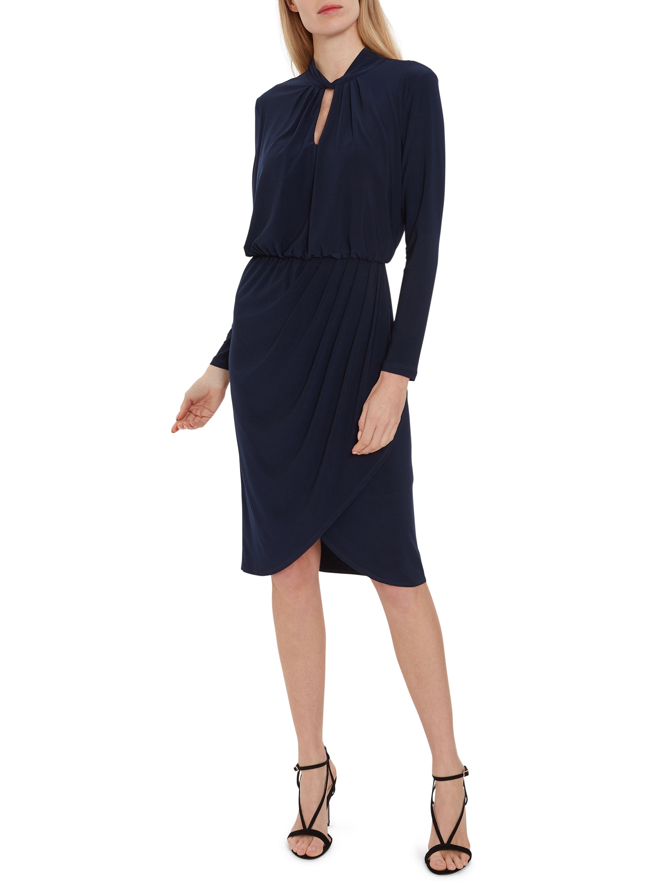 Feel fabulous in this soft stretch jersey dress by Gina Bacconi. It has long sleeves and keyhole neck detailing, with delicate ruching at the waistline and a wrap over style finish. Perfect for day to evening wear. The dress is fully lined.