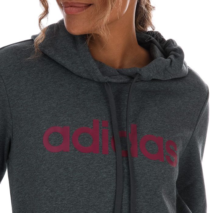 Womens adidas Essentials Linear Hoody in charcoal marl.- Crossover neckline.- Long sleeves.- Two side pockets.- Ribbed cuffs.- adidas logo across the chest.- Regular fit.- 52% Cotton  48% Polyester (Recycled) . Hood lining: 100% Cotton.  Machine washable. - Ref: GD2963