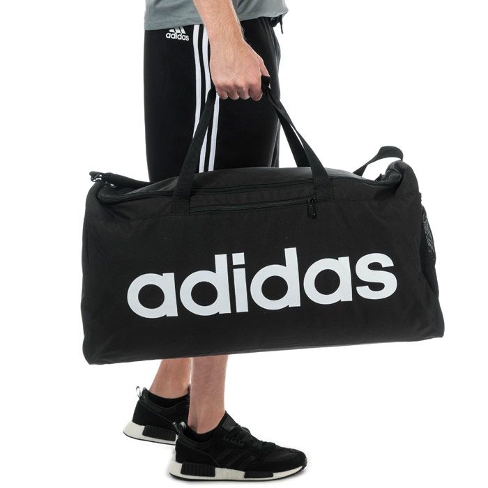 adidas Linear Core Duffel Bag - Large in black - white.<BR><BR>- Main compartment with dual zip fastening.<BR>- Elasticated inner slip compartment for shoes or laundry.<BR>- Zipped front pocket.<BR>- Mesh slip pocket to side.<BR>- Adjustable webbing shoulder strap with padding.<BR>- Webbing carry handles with padding.<BR>- adidas linear logo to front.<BR>- 75.6 litre capacity.<BR>- Dimensions: 34cm (H) x 65cm (W) x 27cm (D) approximately.<BR>- Main material: 51% Recycled polyester  49% Polyester.  Lining: 100% Polyester.  Padding: 100% Polyethylene.  Sponge clean only.<BR>- Ref: DT4824<BR><BR>Measurements are intended for guidance only.