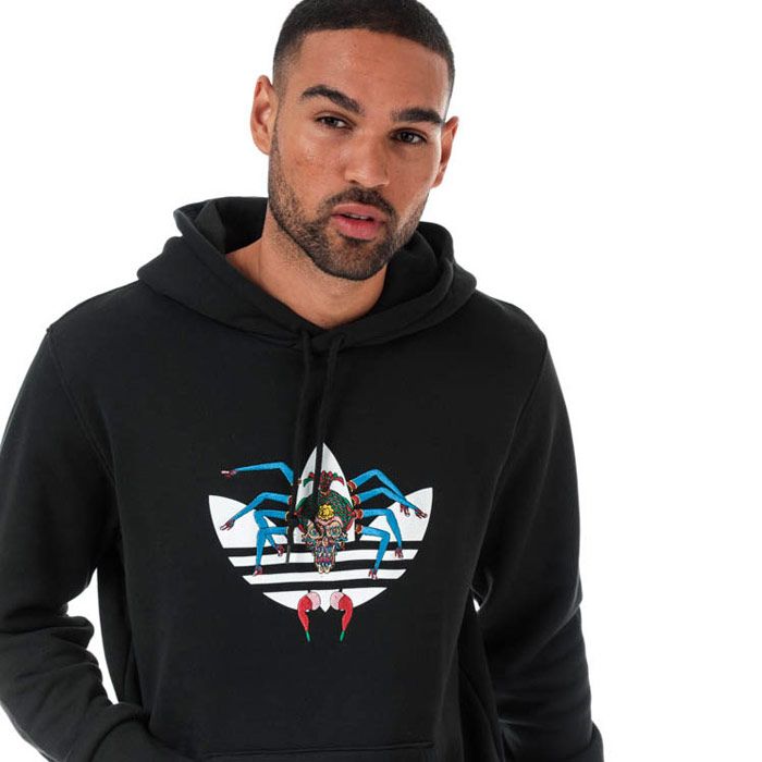 Mens adidas Originals Tanaami Hoody in black. – Created in collaboration with Japanese artist Keiichi Tanaami. – Drawcord-adjustable hood. – Long sleeves. – Printed Trefoil logo to front with embroidered graphic. – Kangaroo style pocket to front. – Ribbed cuffs and hem. – Regular fit. – Main material: 100% Cotton.  Hood lining: 100% Cotton.  Machine washable. – Ref: DY6691