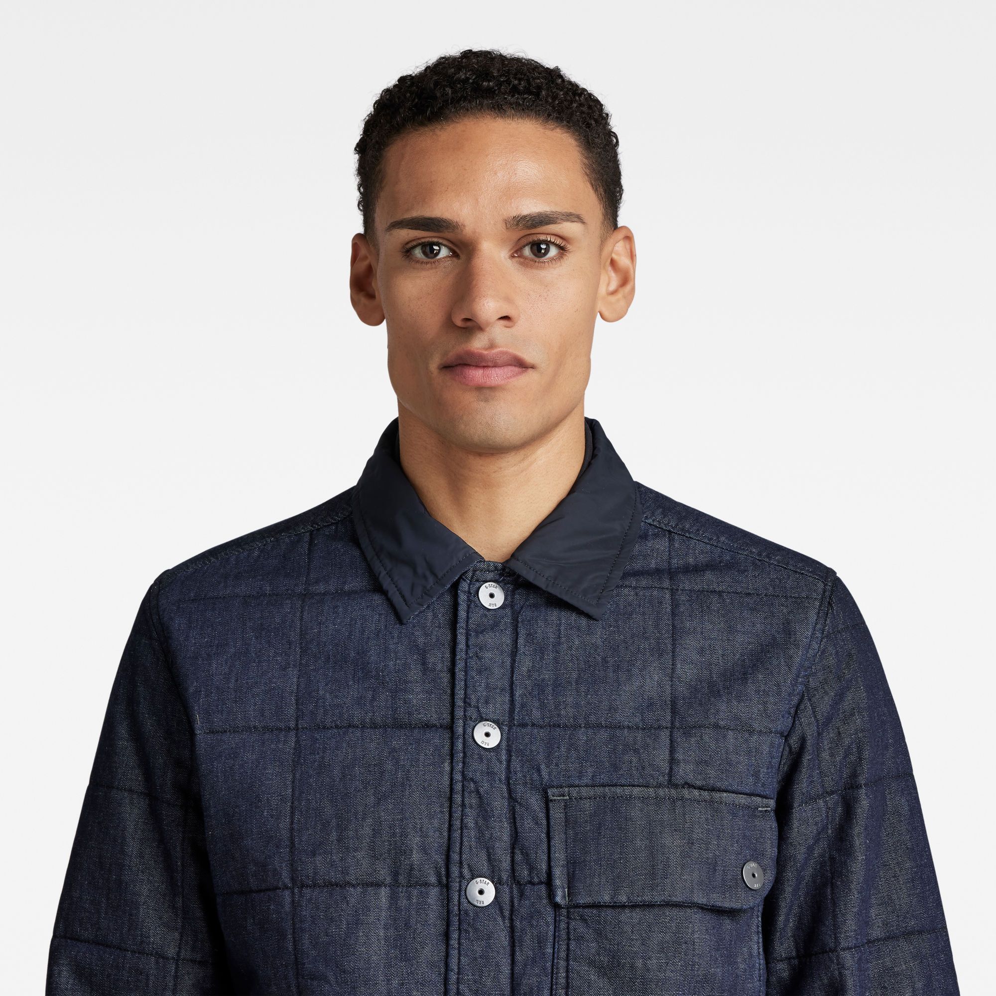 Flat collar- inner rib collar. Long sleeves, cuffed- snap button closure. Chest pocket with flap and snap button closure- side entry pocket underneath. Side seam pockets. Side slits. Snap button closure. Snap closure. A lightweight denim with a rich, uneven surface texture. Lightweight 7 oz denim. Straight
