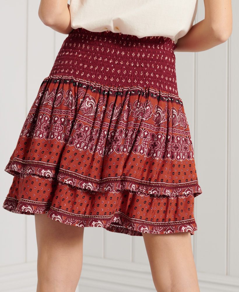 Get the ultimate boho vibe with the vintage inspired Ameera Mini Smocked Skirt, featuring a smocked waistband, and beaded hems.Smocked waistLace detailingBeaded hemsSignature logo tabSignature logo metal badgeAll over print
