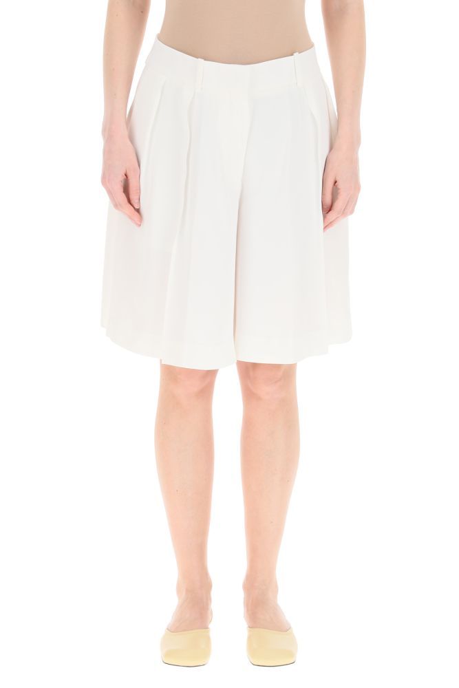 KHAITE shorts in flowing cady featuring a wide leg cut with front pleats, side slash pockets and rear welt pockets. Front concealed zip and hook closure, belt loops. The model is 177 cm tall and wears a size US 4.
