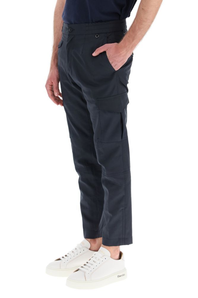 Cargo trousers by ETRO in cotton fabric featuring side pockets with flap, double snap button and central gusset. It features a slightly slim fit with slash pockets, a small front pocket, and back pockets with flap and button. Closure with zip and branded button, elasticated waistband and knotted internal drawstring. The model is 183 cm tall and wears a size IT 46.