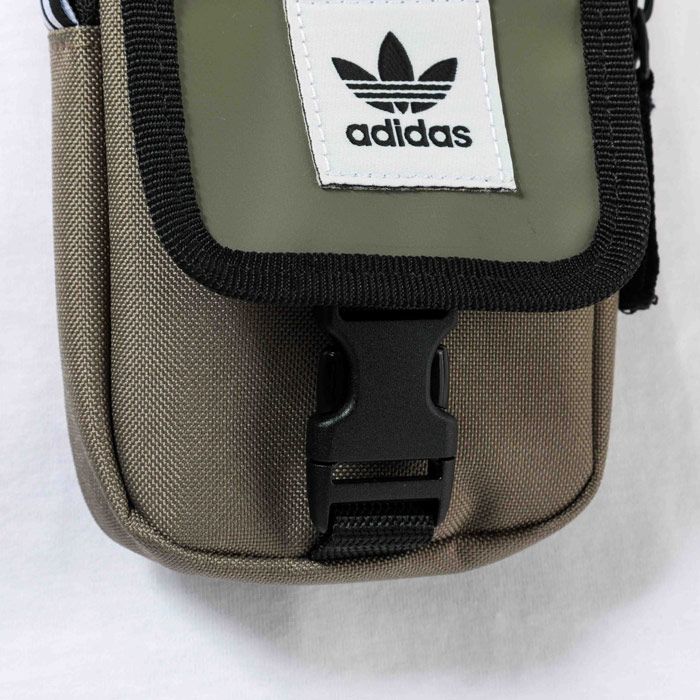 adidas Originals Map Bag Khaki.  <BR><BR>- Compact and lightweight.<BR>- Woven polyester body with flap closure.<BR>- One main zip compartment.<BR>- Woven 3- stripe tab to side.<BR>- Trefoil branding to front.<BR>- Woven shoulder strap.<BR>- Depth 3cm  Width 11cm  Length 17cm approximately.<BR>- 100% Polyester.<BR>- Ref: ED8057