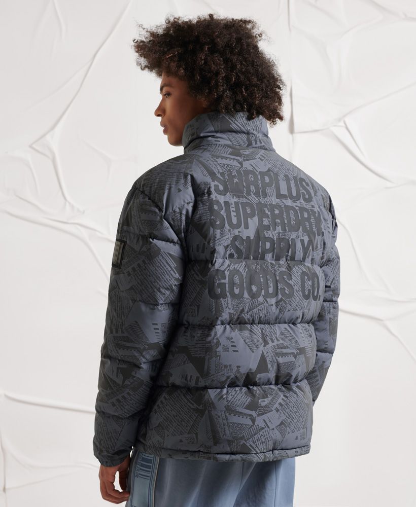Dare to be seen in our grime inspired Surplus Reflective Down Puffer Jacket.Relaxed fit – the classic Superdry fit. Not too slim, not too loose, just right. Go for your normal size.90/10 Down fillingReflective patternMain zip fasteningTwo front zip pocketsElasticated popper cuffsD ringBungee cord hemPrinted liningOne internal pocketRubberised Superdry logo patchIconic Superdry logo tabSuperdry is certified by the Responsible Down Standard to confirm that our down filled products are sourced to ensure animal welfare.XS/S: 34