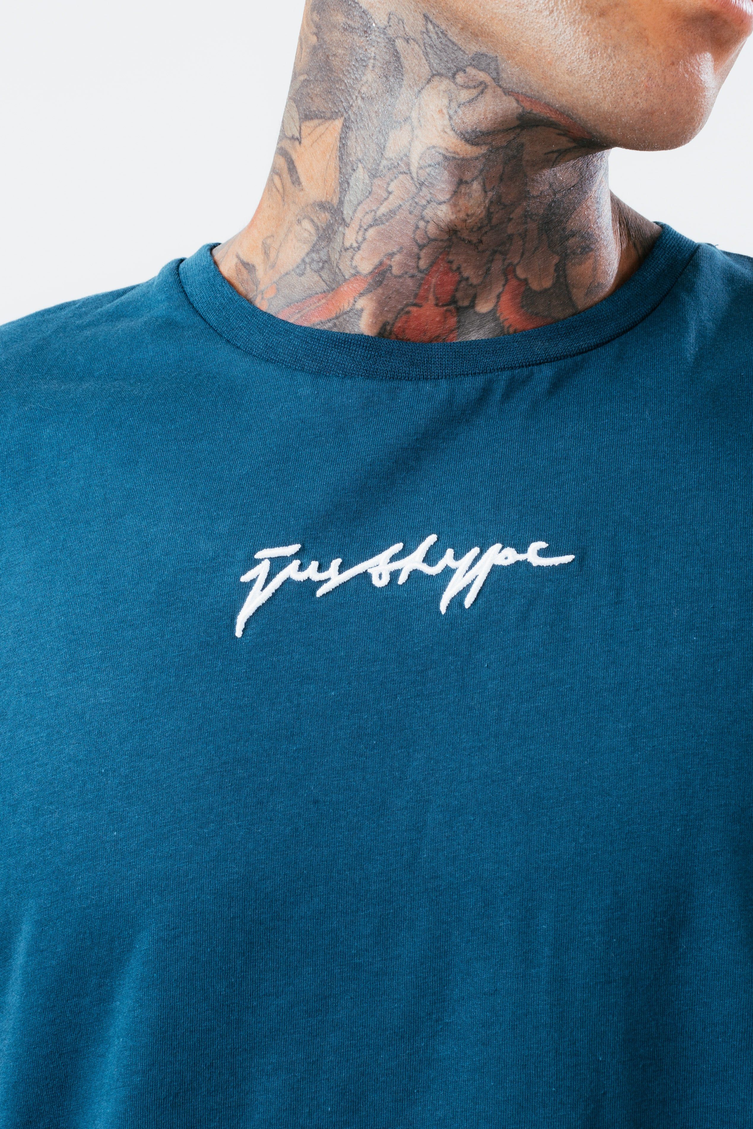 The HYPE. Midnight Teal Scribble Men's T-shirt boasts a soft touch fabric base for supreme comfort in a teal and white colour palette. Designed in our standard men's tee shape, with a crew neckline and short sleeves for a classic fit. Finished with the new! justhype signature logo embroidered on the front. Machine washable.