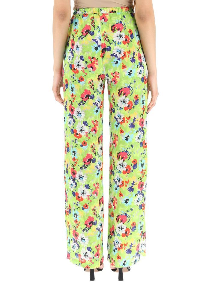 MSGM loose-fit satin trousers with all-over floral print, featuring elasticated waistband and inseam pockets. The model is 177 cm tall and wears a size IT 38.
