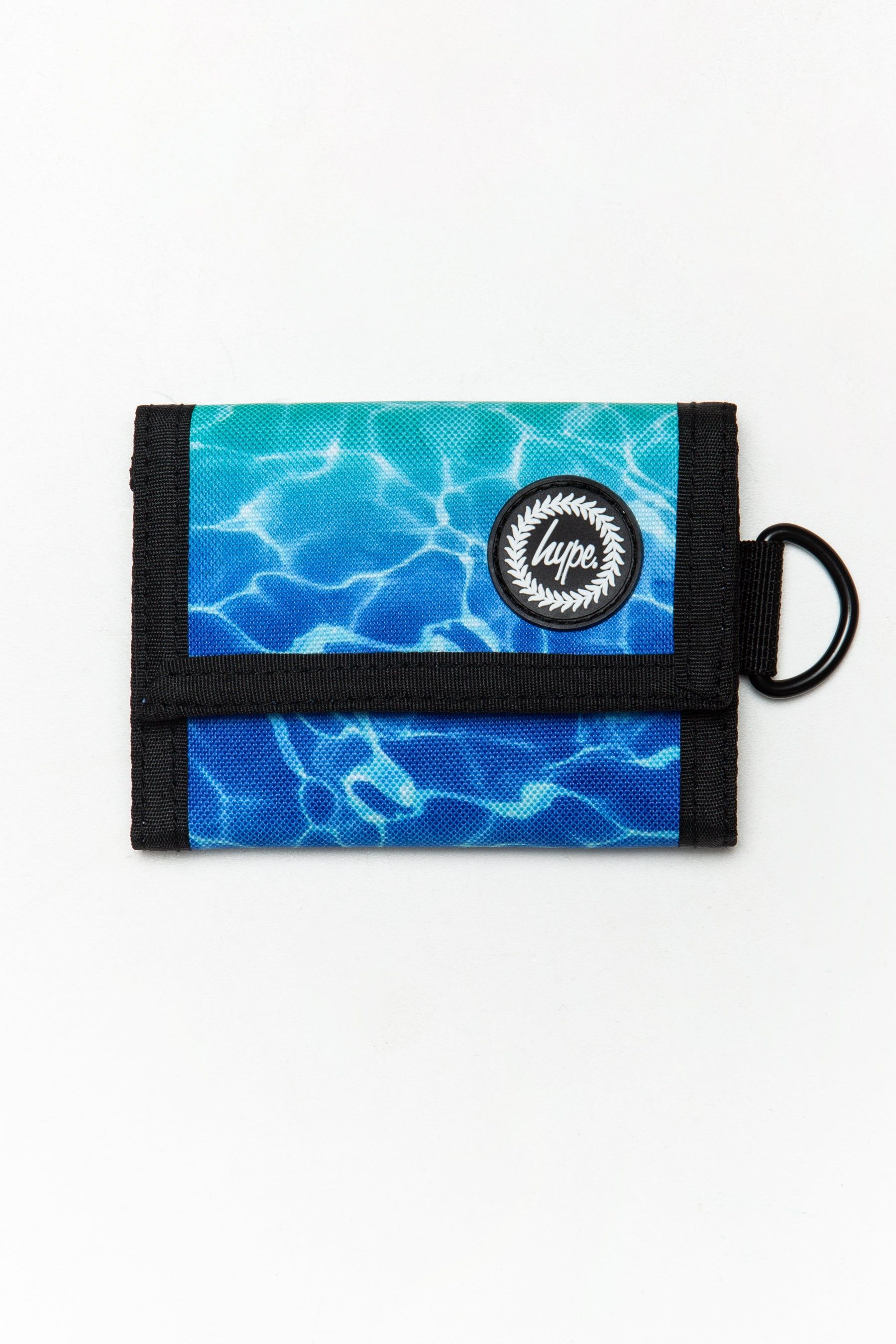 let us introduce you to the HYPE. Pool Fade Wallet. A unisex wallet shape and design, creating the perfect lightweight wallet you need as your money and card holder. Featuring an all-over swimming pool water inspired print in a green, turquoise and blue gradient fade colour palette. Finished with Velcro fastening and the iconic HYPE. crest logo in a raised rubber fabric. Wipe clean only.