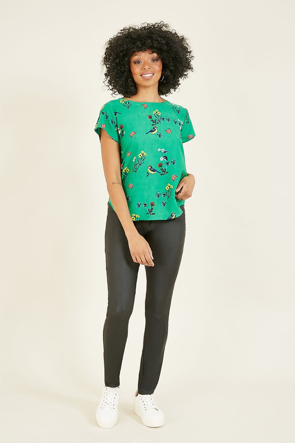 This Yumi Green Bird Print Short Sleeve Top is stylish, elegant and practical. Features a delicate bird print and bold green base. Match wide legged trousers or skinny jeans to complete the look.