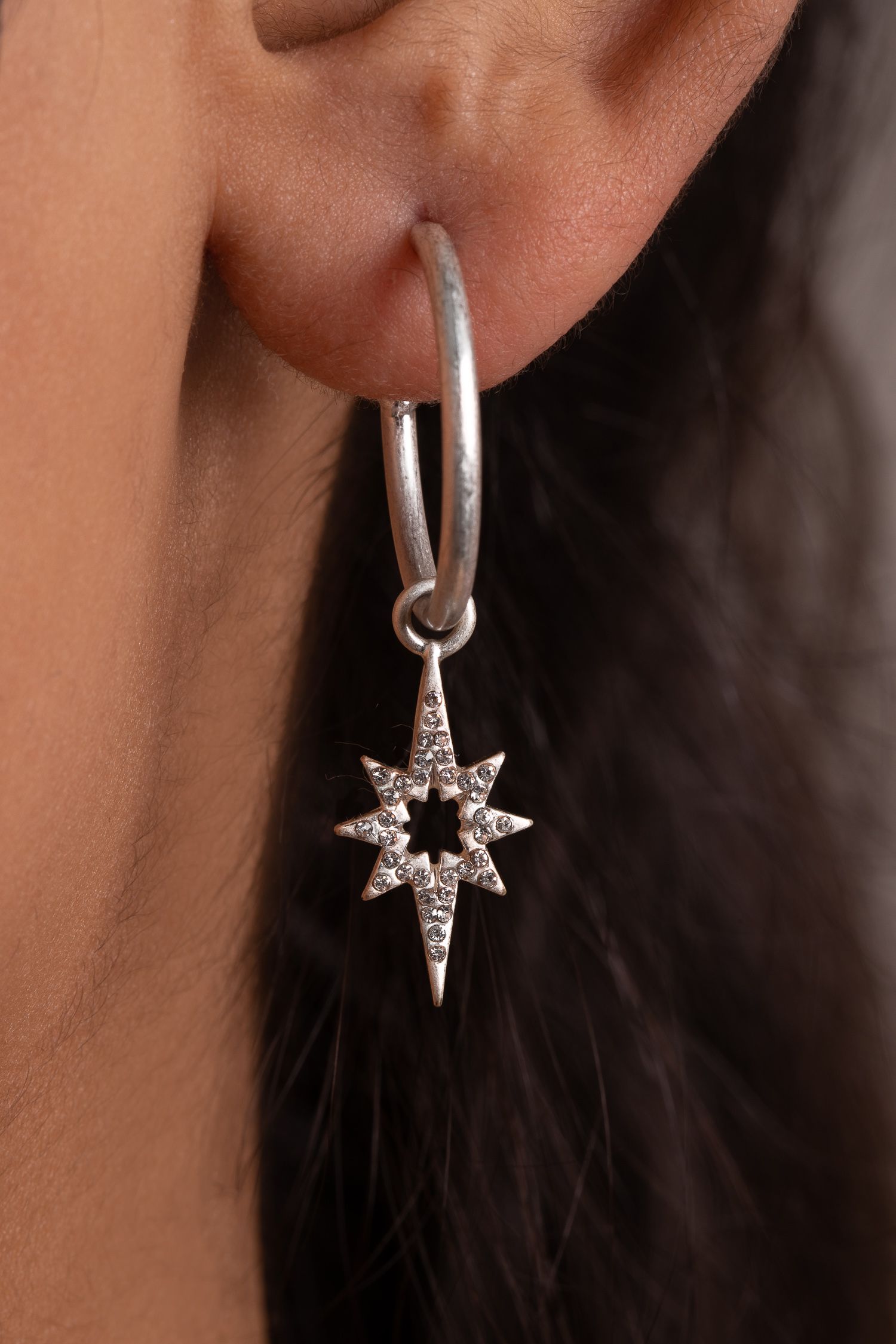Our new Kate Thornton silver plated 'Celeste' star drop earrings will really make a style statement this season. A striking piece of jewellery which makes the perfect accompaniment to any outfit.  Delicate, eye catching and with a contemporary edge these drop earrings will look great when worn alone or paired with other styles for a really on trend look. The silver tone earrings feature an 18mm hoop and delicate 27mm pave star charm. Presented in a KTx jewellery pouch to keep your jewellery safe or ideal for gifting!