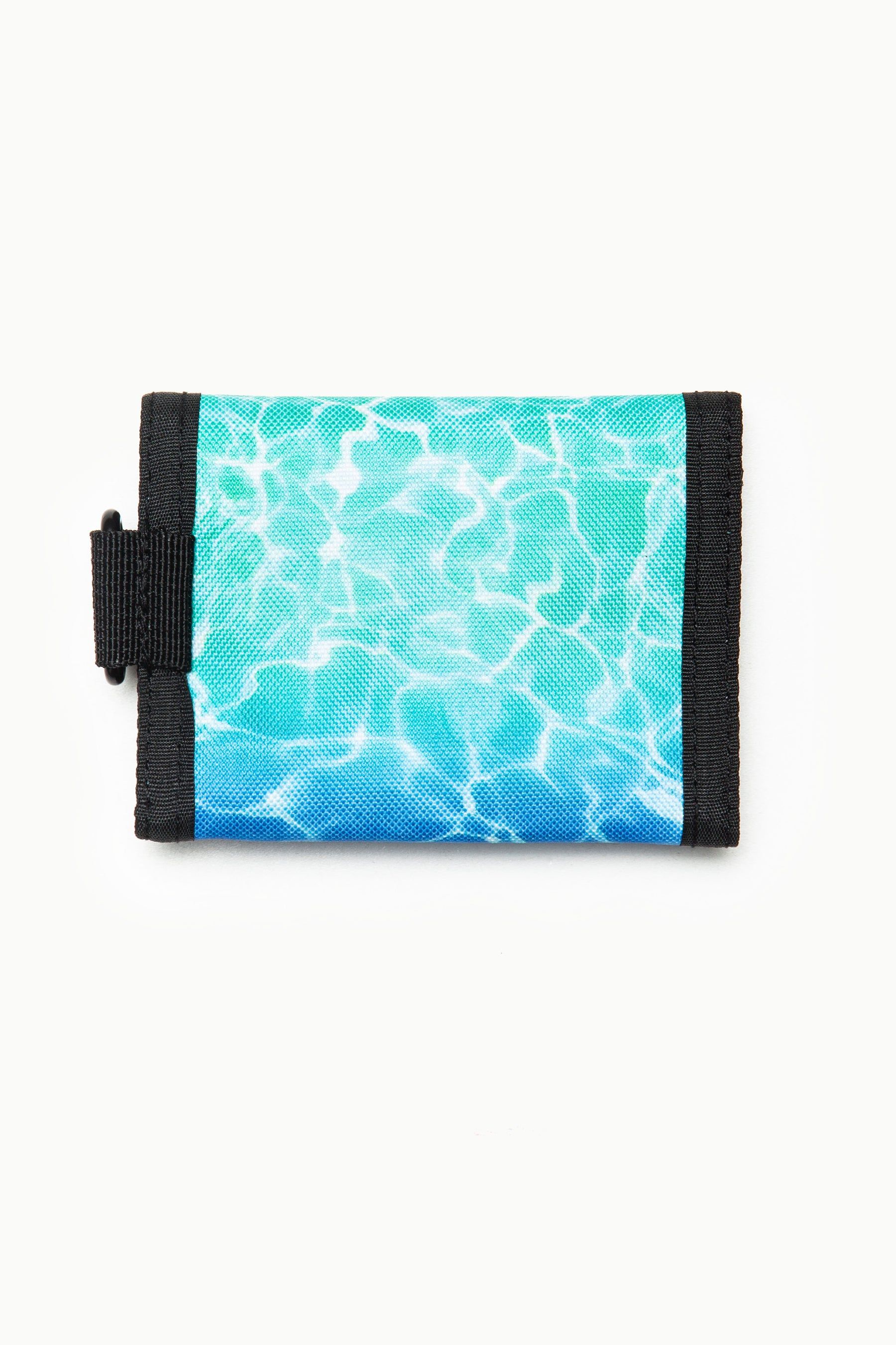 let us introduce you to the HYPE. Pool Fade Wallet. A unisex wallet shape and design, creating the perfect lightweight wallet you need as your money and card holder. Featuring an all-over swimming pool water inspired print in a green, turquoise and blue gradient fade colour palette. Finished with Velcro fastening and the iconic HYPE. crest logo in a raised rubber fabric. Wipe clean only.