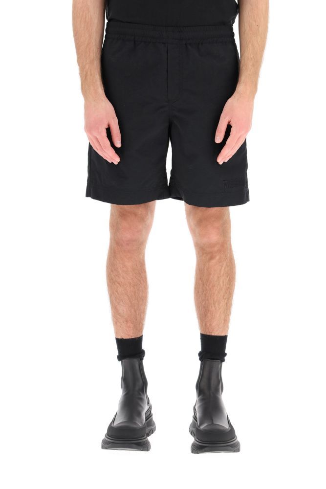 MSGM loose fit bermuda shorts in nylon with elasticated waistband adjustable with internal drawstring. It features side slit pockets, a back patch pocket and ton sur ton logo embroidery on the hem. The model is 183 cm tall and wears a size IT 46.
