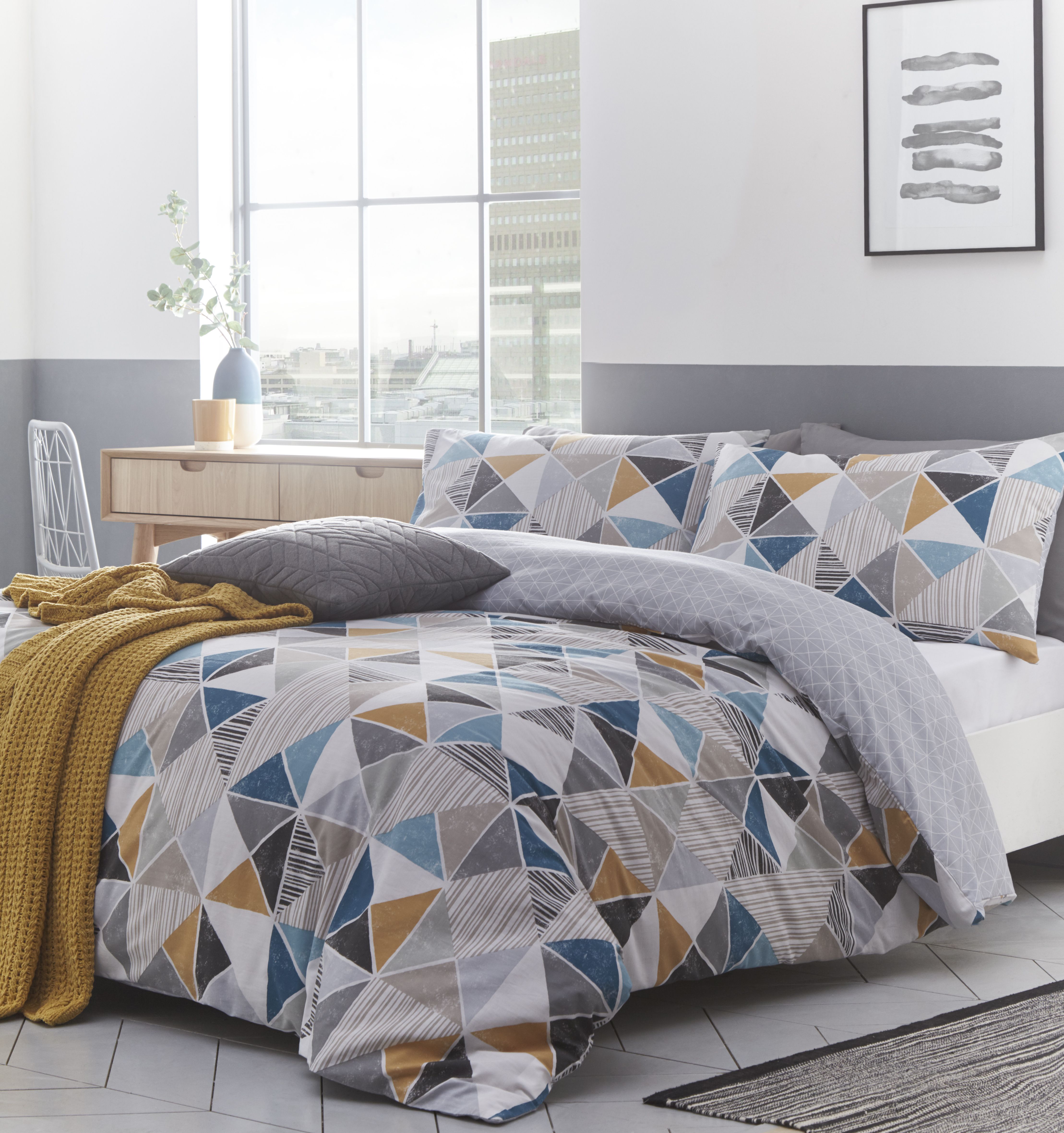 The striking geometric design of the Harlequin duvet cover and pillow case set creates a tapestry of shapes that perfectly fit together with squares, triangles and diamonds jumping out in different colours and designs. The main colour scheme of this gorgeous duvet features white, grey and beige with shocks of orange and teal making this pattern pop. The reverse features a defused light grey design to draw attention to the audacious front. Made of crisp polycotton making this duvet set soft and hard-wearing. This duvet cover features a secure button closure while the pillowcases have an envelope closure. Machine washable on a 40 degree cycle. Iron cool and tumble dry on a low setting for the best finish.