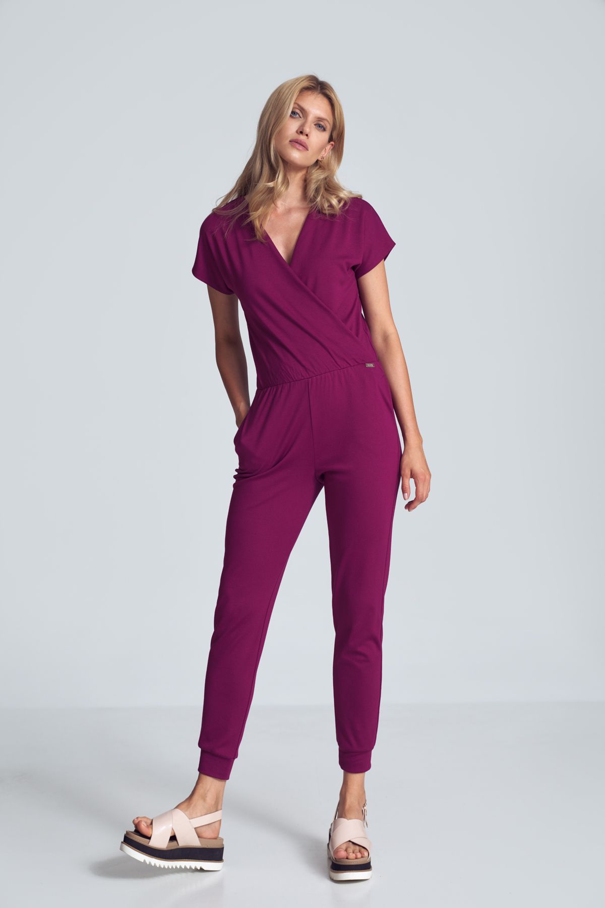 Fuchsia jumpsuit with a sporty cut, wrinkled neckline, an elastic band sewn at the waist, narrow legs finished with a welt. Pockets in the side seams.