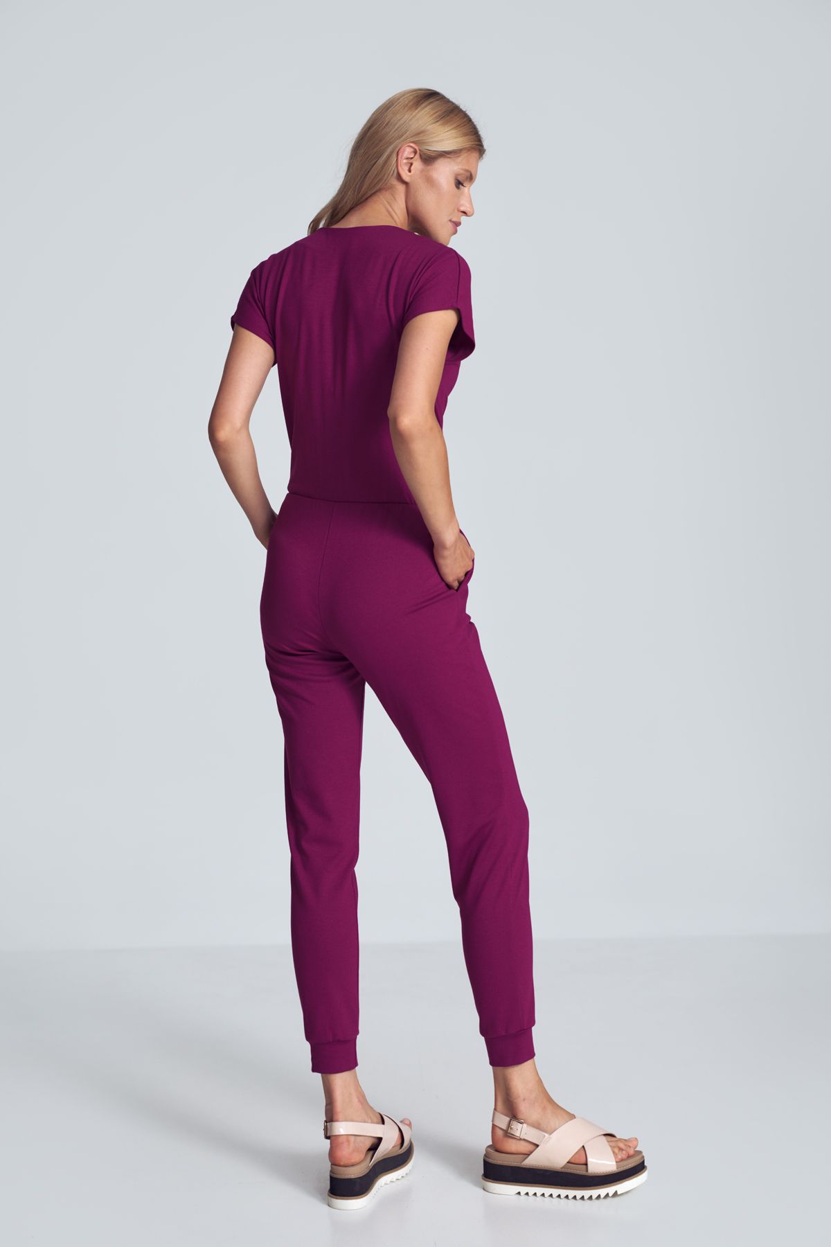 Fuchsia jumpsuit with a sporty cut, wrinkled neckline, an elastic band sewn at the waist, narrow legs finished with a welt. Pockets in the side seams.