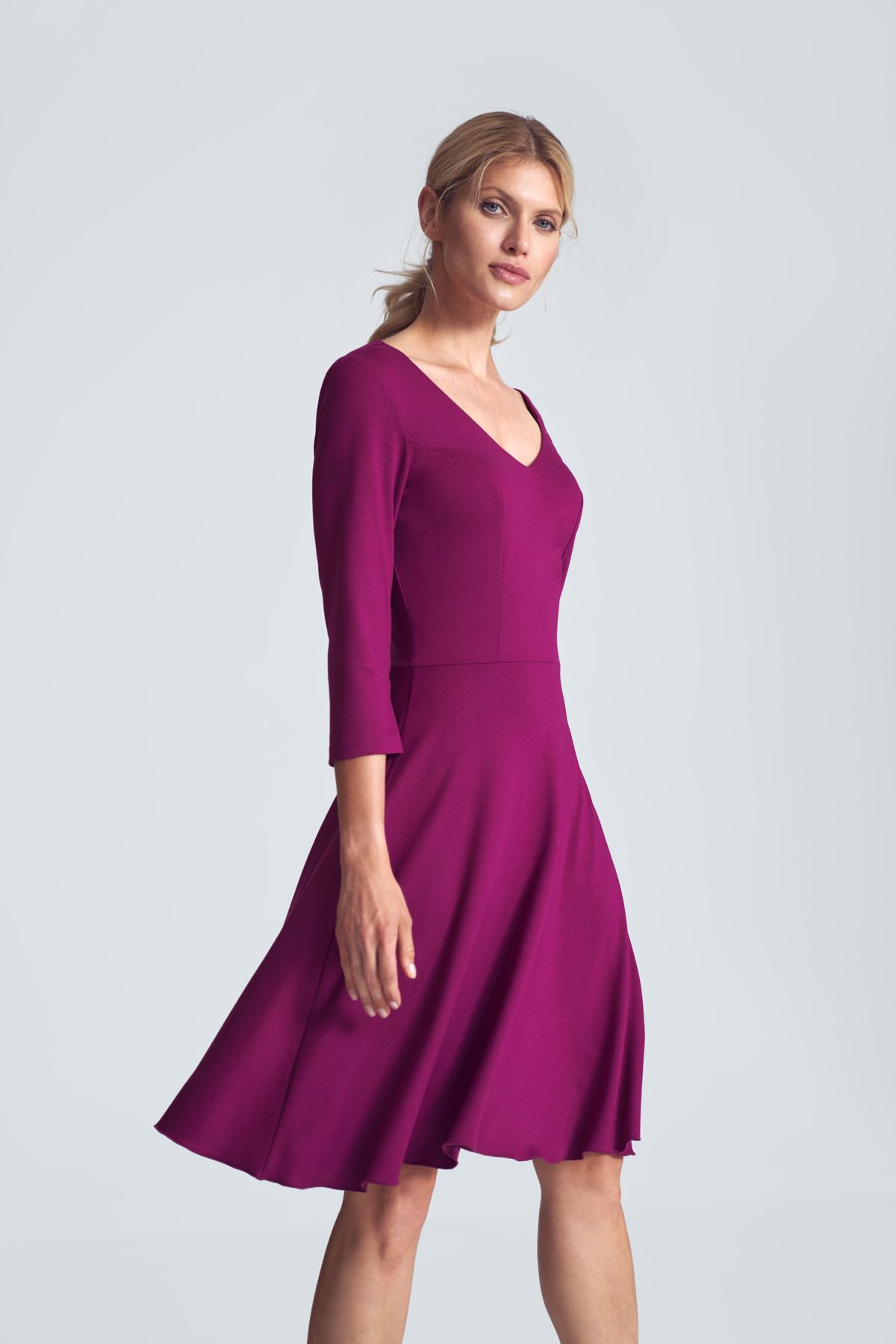 Fuchsia cocktail midi dress with a V-neck, ¾ sleeve, pleats at the bust, sewn at the waist, flared hem. Fastened at the back with a covered zipp.