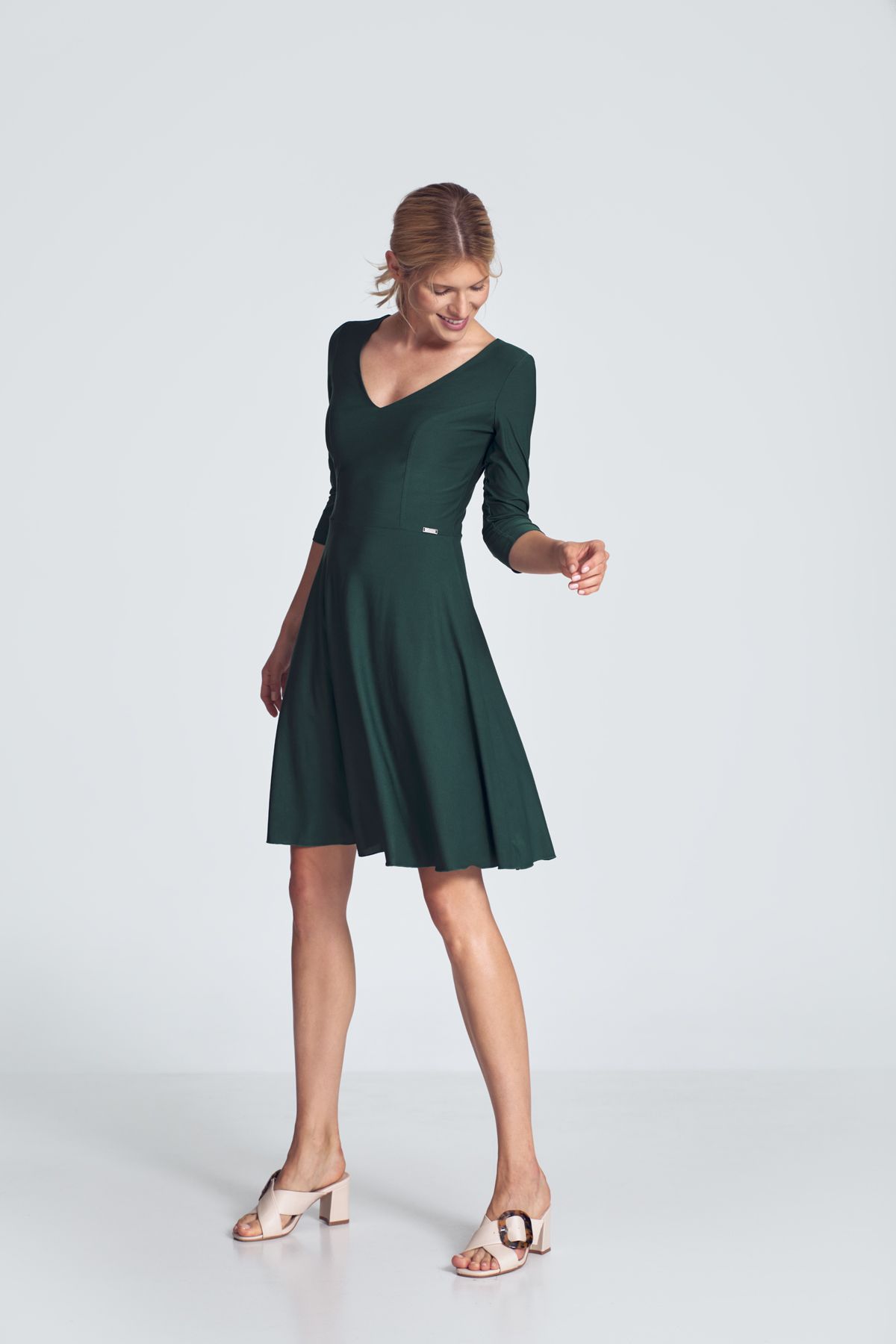Green cocktail midi dress with a V-neck, ¾ sleeve, pleats at the bust, sewn at the waist, flared hem. Fastened at the back with a covered zipp.