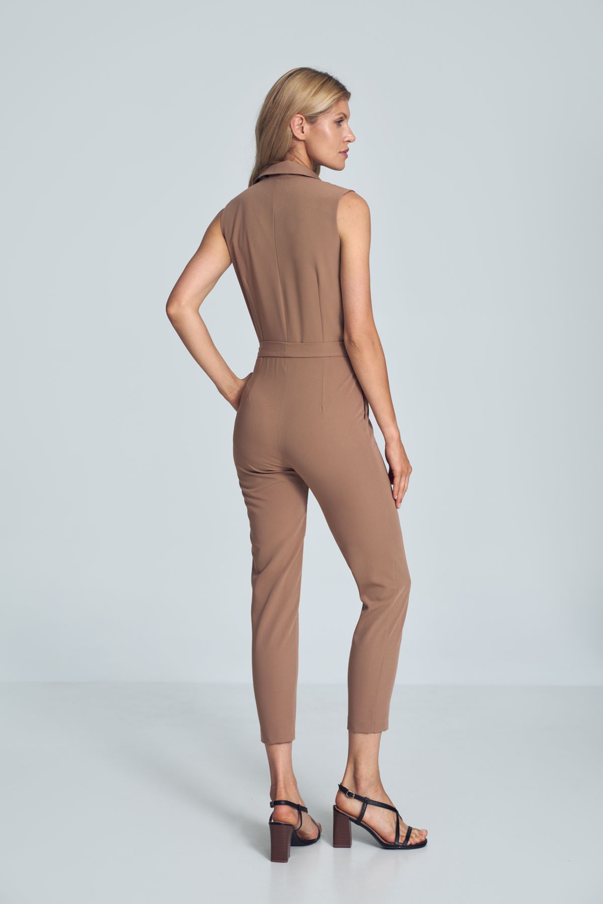 Brown V-neck jumpsuit with a collar, sleeveless, tied at the waist, loose legs tapered to the bottom. Fastened at the front at the waist with one external and internal snaps and a covered zipper. Pockets in the side seams.
