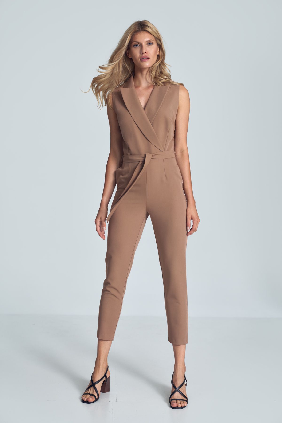 Brown V-neck jumpsuit with a collar, sleeveless, tied at the waist, loose legs tapered to the bottom. Fastened at the front at the waist with one external and internal snaps and a covered zipper. Pockets in the side seams.