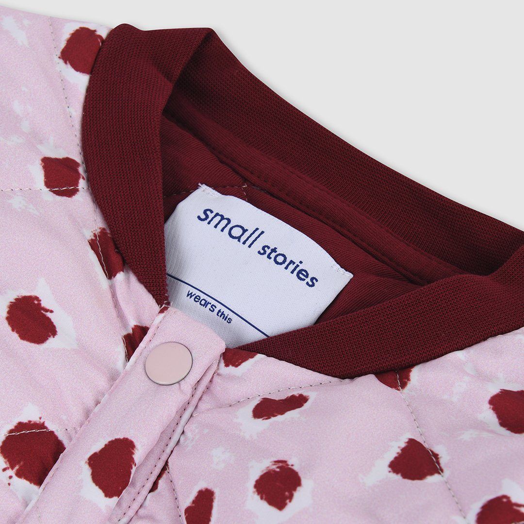 Lightweight cotton mix quilted jacket with our bespoke painted dot print in pale pink with burgundy dots. Inside lining and ribbed collar in matching burgandy jersey to the burgundy dots to give our little ones extra warmth and comfort. Features press stud front opening for ease of dressing.