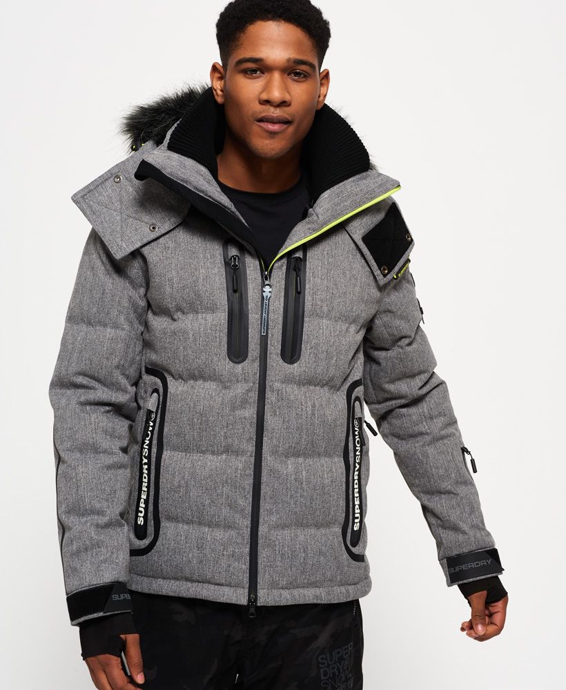 Superdry men’s Deluxe Nordic snow puffer jacket. This padded weather tolerant jacket with an inner ribbed collar, detachable hood with a removable faux fur trim and a taped seam zip fastening is perfect for hitting the slopes in. The Deluxe Nordic snow puffer jacket features five outer pockets – one with a detachable goggle cloth, hook and loop fastened cuffs with thumbholes and zip fastened armpit ventilation. Inside, the jacket has a removable snow skirt and a single internal pocket with earphone routing. The jacket is finished with Superdry branding on the zips, placket, shoulder and arms. Water resistance  10,000mm 
Breathability  10,000g
Snow seals and coated zipsModel wears: Medium Model height: 6’ 1” (185cm) Model chest size: 38