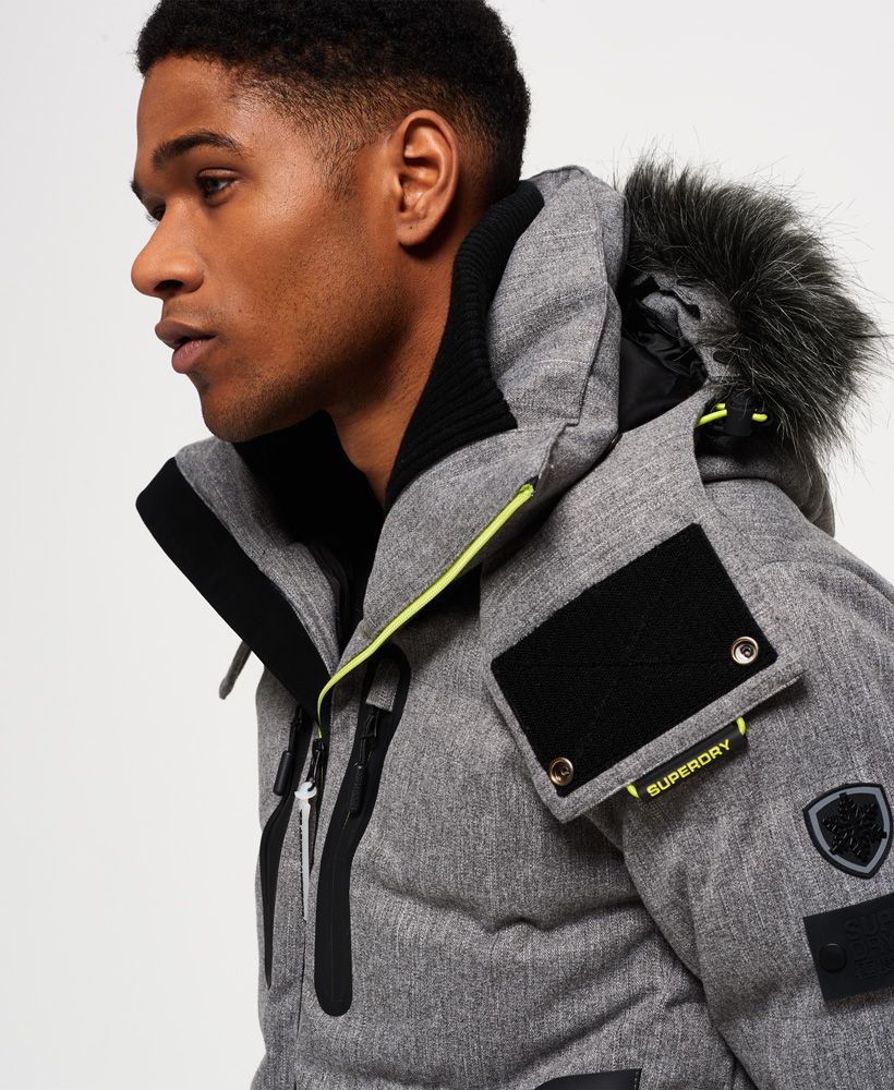 Superdry men’s Deluxe Nordic snow puffer jacket. This padded weather tolerant jacket with an inner ribbed collar, detachable hood with a removable faux fur trim and a taped seam zip fastening is perfect for hitting the slopes in. The Deluxe Nordic snow puffer jacket features five outer pockets – one with a detachable goggle cloth, hook and loop fastened cuffs with thumbholes and zip fastened armpit ventilation. Inside, the jacket has a removable snow skirt and a single internal pocket with earphone routing. The jacket is finished with Superdry branding on the zips, placket, shoulder and arms. Water resistance  10,000mm 
Breathability  10,000g
Snow seals and coated zipsModel wears: Medium Model height: 6’ 1” (185cm) Model chest size: 38