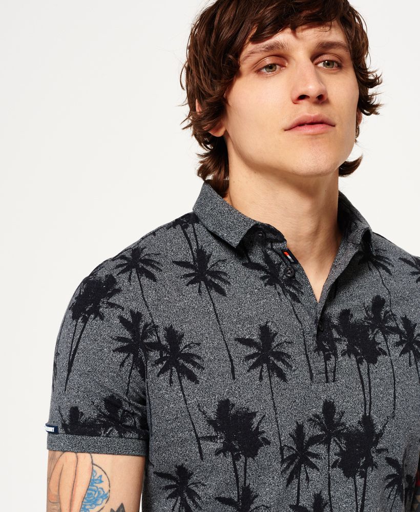 Superdry men’s City all over print polo shirt. A short sleeve jersey polo shirt that has a three button fastening and an all over palm tree print fabric. A lightweight polo shirt that can be paired with International chino shorts for a fresh summer look. The City polo shirt is finished with a Superdry logo badge on the sleeve and a tri-colour logo patch in the placket. Model wears: Medium Model height: 6’ 1” (185cm) Model chest: 37