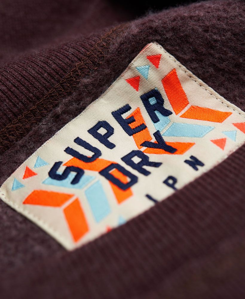 Superdry women's Tassel Crew. A wide crew neck jumper with a hand brushed style Superdry print across the front. The Tassel Crew also features a sequin embellishment and a zip that runs half way up the side with a tassle pull.