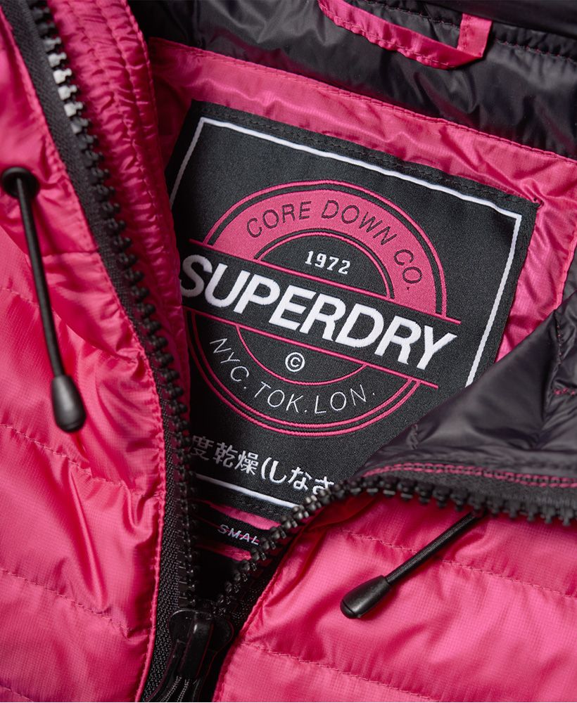 Superdry women’s Core down hooded jacket. This lightweight, down and feather quilted jacket is the perfection transitional wardrobe piece and features an elasticated hood, cuffs and hem, zip fastening and two front pockets. The Core down hooded jacket is finished with branded zip pulls and a rubber Superdry logo badge on one sleeve.Model wears: 10/Small Model height: 5’11” (181cm) Model chest size: 31