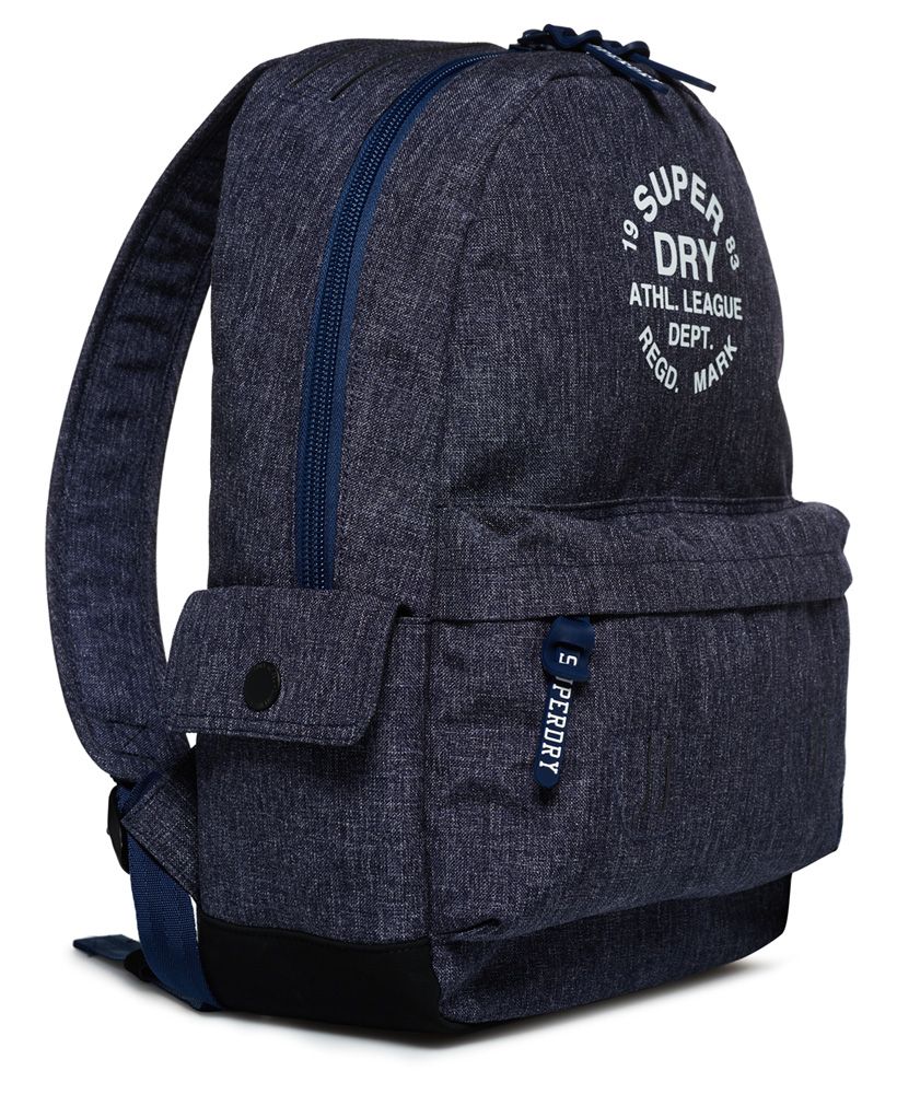 Superdry women’s Athletic League Montana rucksack. A rucksack with a top grab handle, padded back and straps and a large main compartment. The Athletic League rucksack features twin side pockets with popper fastening and a zipped outer compartment and is finished with branded zip pulls and a Superdry Athletic League print on the front and logo patch on the front pocket. 
17 litre approximate capacity 
H 45cm x L 30cm x D 13cm.