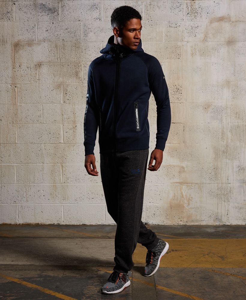 The Tech range from the Superdry Sport collection has a slimmer fit and is designed to be worn as a warm up/warm down layer over the Runner range. Cool, comfortable and on top of your game! Superdry’s brand new sport collection for men is designed for high performance.Superdry men’s gym tech zip hoodie. This zip hoodie features a bungee cord adjustable hood, ribbed cuffs and hem and a front zip fastening. Featuring two front pockets and one back pocket this gym tech hoodie has Superdry sport brand detailing on the zipped pockets and bungee cord. Model wears: Medium Model height: 6’ 1” (185cm) Model chest size: 38