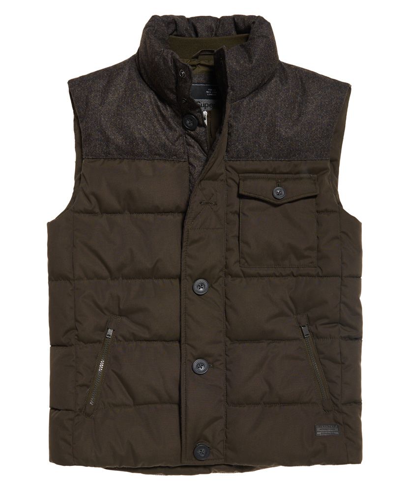 Superdry men's Tech Tweed gilet. Perfect for that heritage look, the Tech Tweed gilet is a classic quilted gilet with a mottled tweed effect shoulder panel. The gilet fastens with a zip, button and popper fastening and has two zipped pockets and a patch chest pocket. Inside there is a small ribbed inner collar and a single pocket with a popper fastener. The Tech Tweed gilet is finished with a Superdry logo patch above the hem.Model wears: Medium Model height: 6’ 1” (185cm) Model chest size: 39