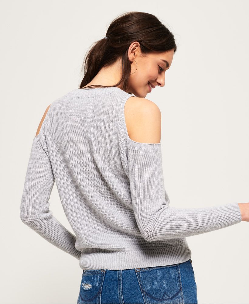 Superdry women’s Beach Club cold shoulder knit top. Be comfortable while looking stylish in this knit top. Featuring a ribbed neckline, cuff and hem and a metallic effect logo across the front. This cold shoulder top is finished with a Superdry logo tab on the hem.