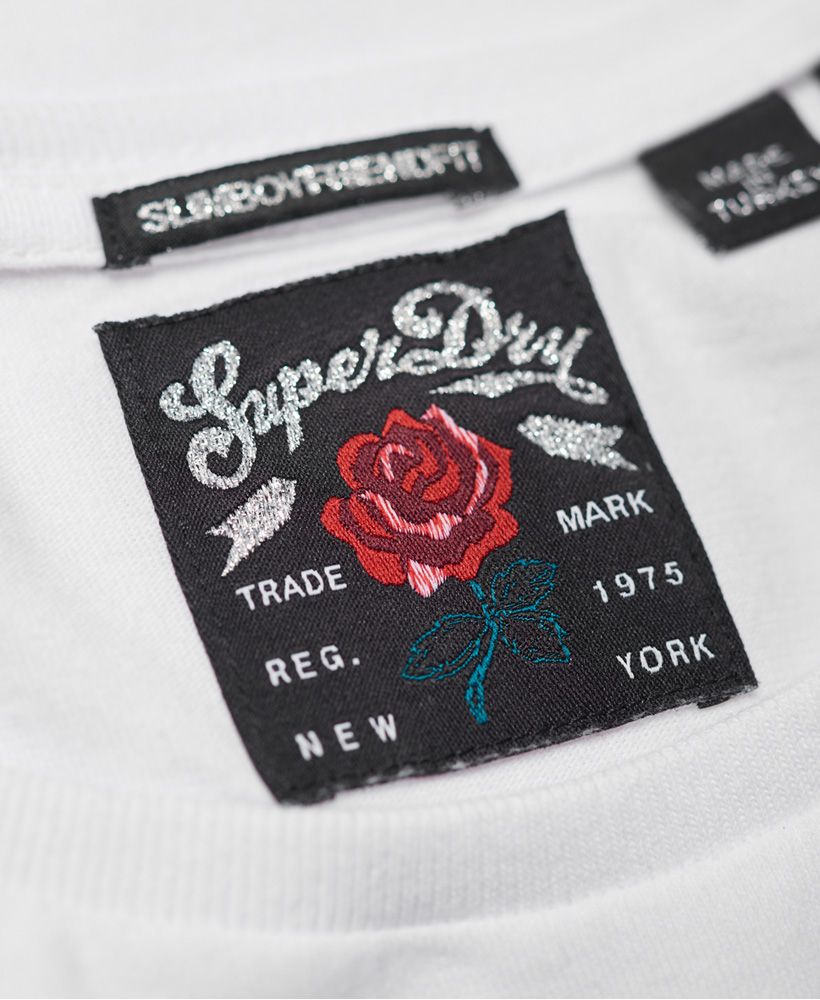 Superdry women’s boyfriend band t-shirt. A crew neck tee featuring a large Superdry logo graphic across the chest and on the reverse. This t-shirt is finished off a paint splatter effect and a logo badge just above the hem.