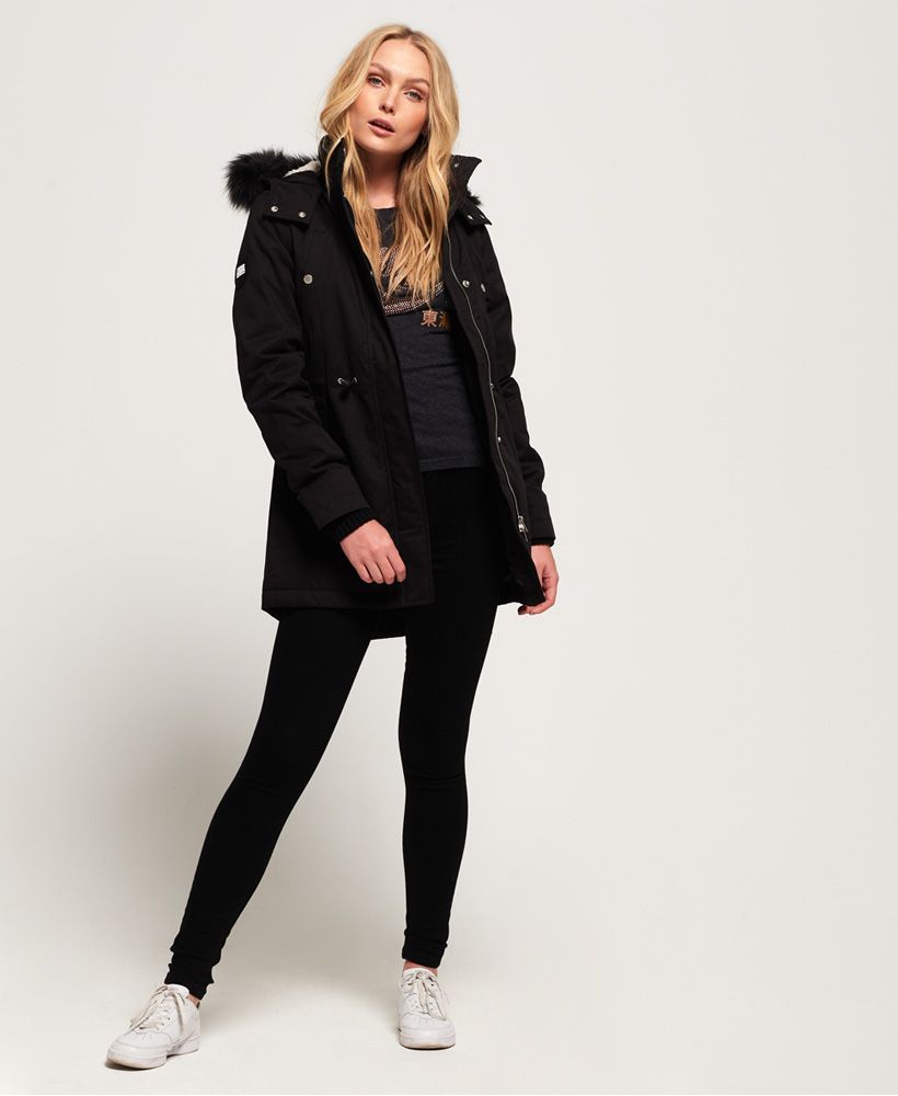 Superdry women’s Model microfibre faux fur jacket. This longer length jacket features a fleece lined hood with a detachable faux fur trim, a ribbed inner collar and a part fleece lining. This jacket also has ribbed cuffs, a bungee cord waistband, four front popper fastened pockets and a zip and popper front fastening. The jacket is finished with a metal Superdry logo badge on one pocket and a rubber Superdry International logo badge on one sleeve.