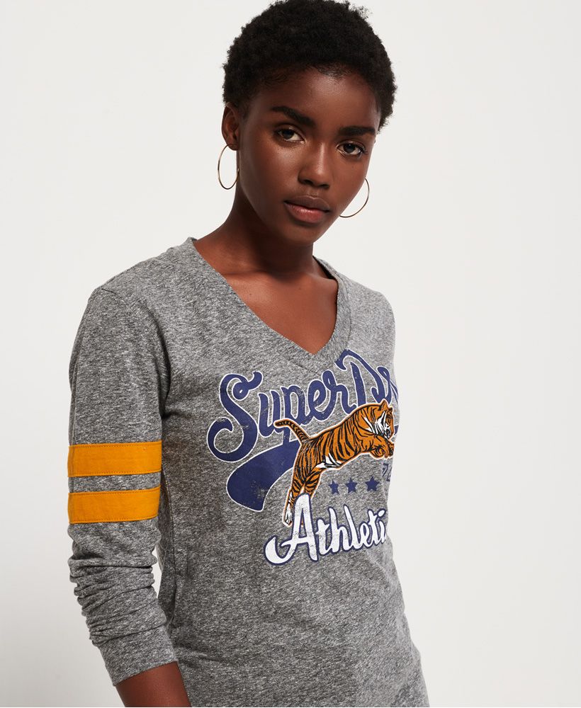 Superdry women’s Mina graphic top. This long sleeved top is a great statement piece for your outfit, featuring a Superdry athletics logo across the chest, a flattering V-neck fit and striped panelling on the sleeves. This tee has been finished with a subtle Superdry tab on the hem. Team this outfit with your favourite jeans this season.