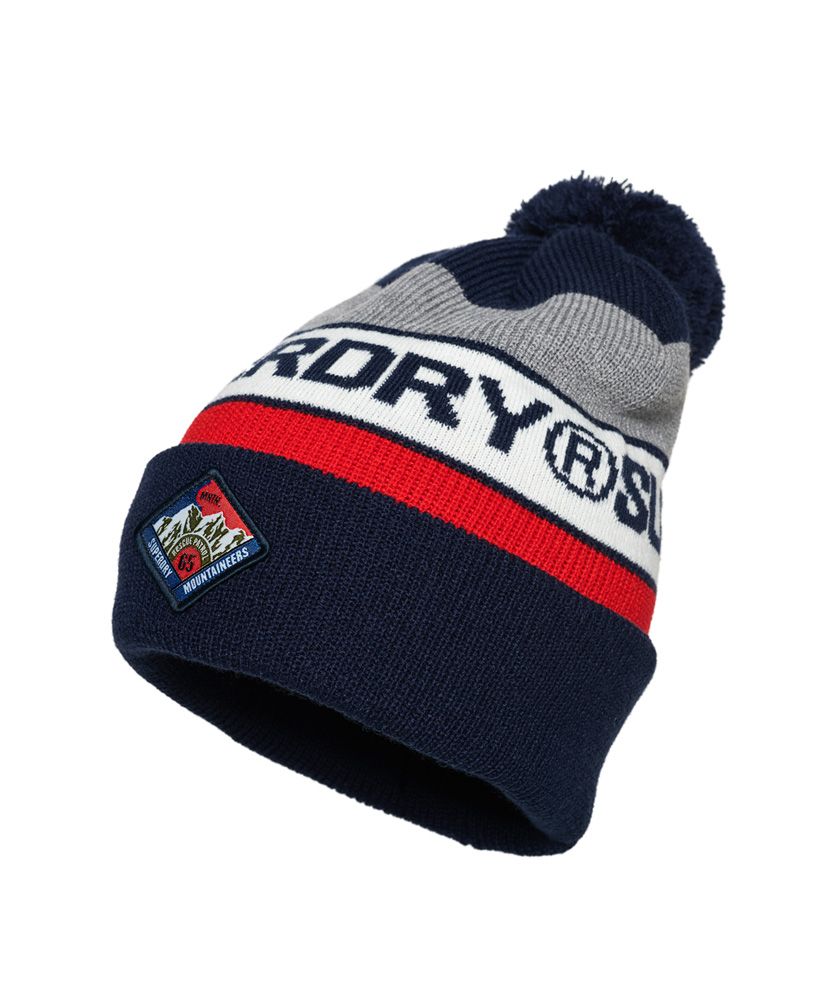 Superdry men’s Trophy beanie. This classic turn up bobble beanie is a great addition to your wardrobe this season to keep you warm whilst still looking stylish. Featuring three colour panels, a Superdry logo incorporated in the stripe design and a Superdry Mountaineers patch on the hem.