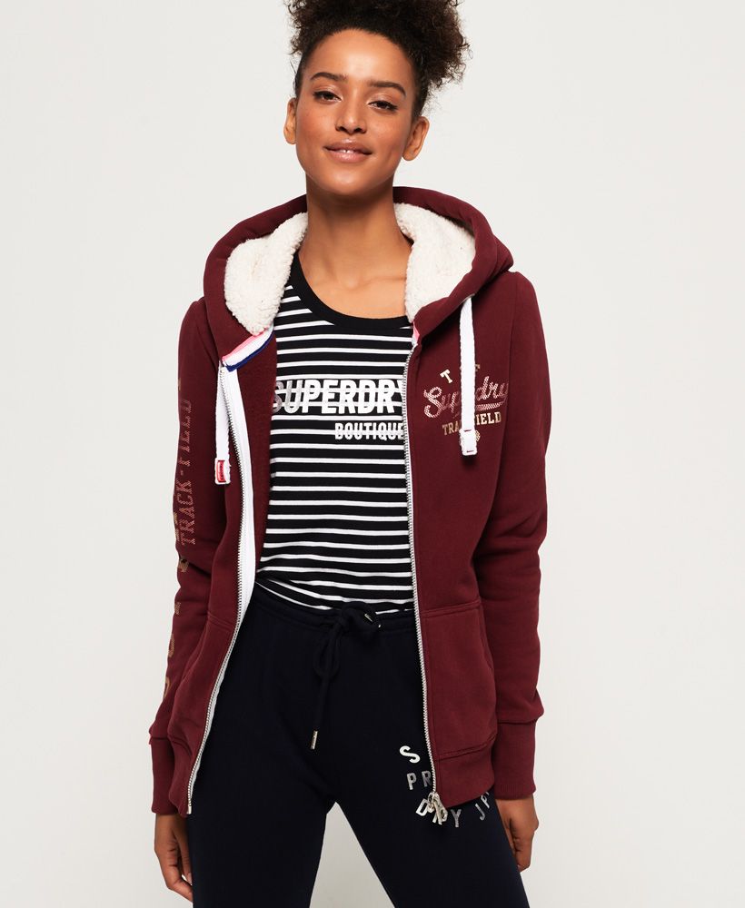 Superdry women’s Track & Field borg zip hoodie. This comfortable zip hoodie adds a laidback element to your outfit, featuring a soft borg lined hood, a zip fastening and a drawstring adjustable hood. The Track & Field borg zip hoodie also features two front pockets, metallic Superdry logos down the sleeve and on the chest and a ribbed hem and cuffs. This hoodie is finished with a Superdry logo tab on the cuff.Slim fit
