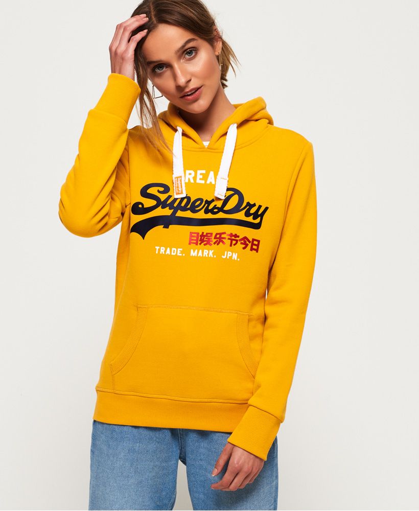 Superdry women's vintage logo bonded satin hoodie. Ideal for a relaxed look, this hoodie is a must-have this season. Featuring a drawstring hood, ribbed cuffs and hem and a front pouch pocket. This hoodie also features a large Superdry logo across the chest in a satin effect, applique badges on the sleeve and is finished with a Superdry logo tab in the side seam.Slim fit