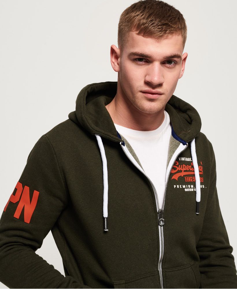 Superdry men’s premium goods duo zip hoodie. For a great layering item this season, look no further than the duo zip hoodie. This cosy hoodie is great to throw on whether you are lounging around the house or hitting the shops, it is a timeless staple for every wardrobe. This hoodie features a draw cord hood, a high-build Superdry logo on the chest and a single zip fastening. In addition, this hoodie also has two handy pockets, ribbed trims and a high-build number logo on the sleeve. For decoration, this hoodie has been completed with a Superdry logo patch on the pocket and an orange stitch in the side seam.