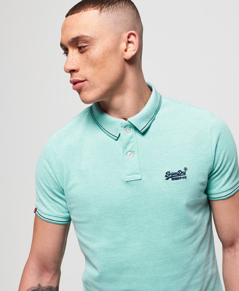 Superdry men's Classic Poolside pique polo shirt. This pique polo shirt features double button fastening, split side seams and an embroidered version of the Superdry logo on the chest. Finished with a logo tab on the hem and stripe detailing around the collar and cuffs, style this polo with a pair of chinos for a great smart yet casual outfit.Made with Organic Cotton - Made using cotton grown using organic farming methods which minimise water usage and eliminate pesticides, maximising soil health and farmer livelihoods.Slim fit