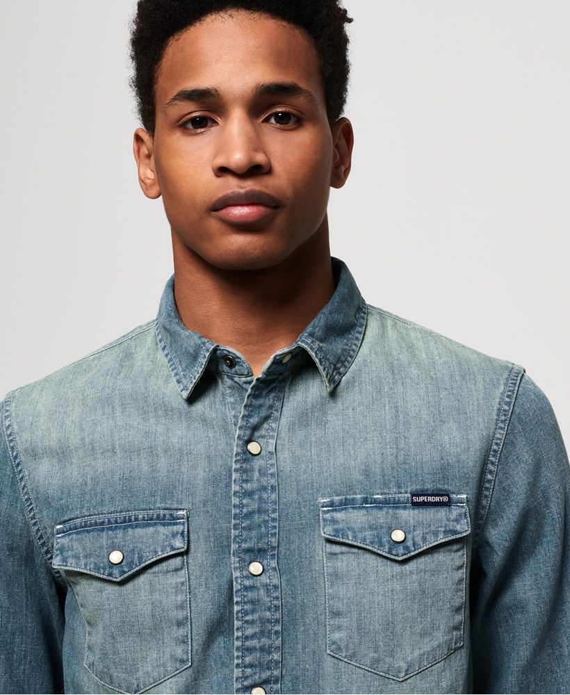 Superdry men's Resurrection long sleeve shirt. This classic denim shirt features a popper fastening, twin chest pockets and popper fastened cuffs. Completed with a logo tab on one pocket, why not wear loose over a plain t-shirt and chinos for a casual, relaxed look.