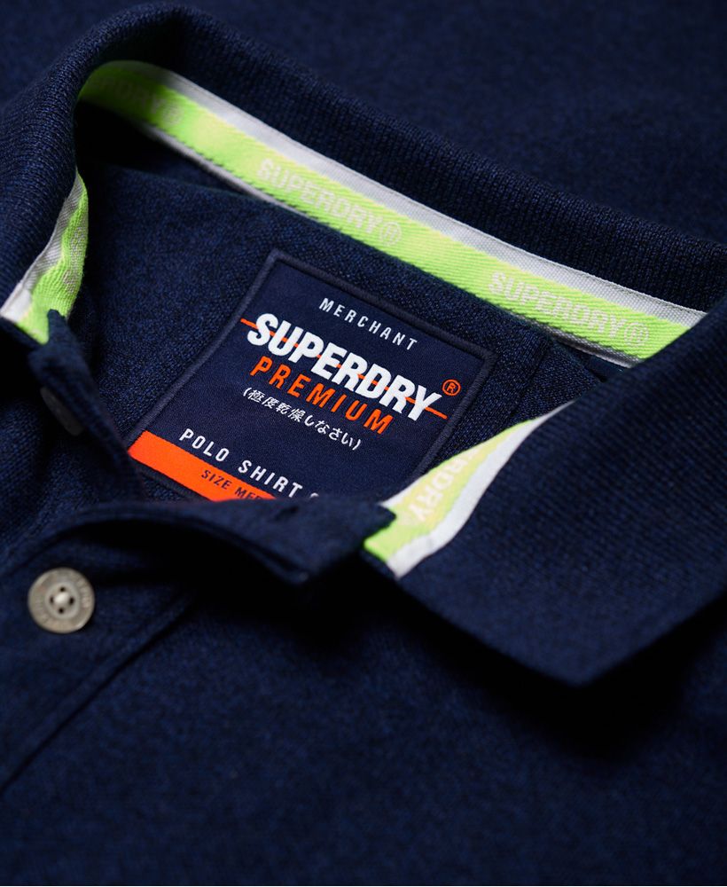 Superdry men's Classic Pique polo shirt. This classic style polo shirt features short sleeves, a two button fastening, reinforced split side seams and an embroidered Superdry logo on the chest. Finished with an embroidered number on one sleeve, a Superdry logo tab on the hem and on one sleeve.Made with Organic Cotton - Made using cotton grown using organic farming methods which minimise water usage and eliminate pesticides, maximising soil health and farmer livelihoods.Slim fit
