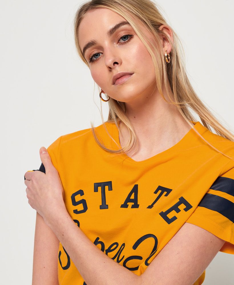 Superdry women’s Varsity State t-shirt. A classically styled crew neck t-shirt featuring a cracked effect Superdry State logo across the chest and finished with acrylic stripe detailing on the sleeves.Relaxed fit