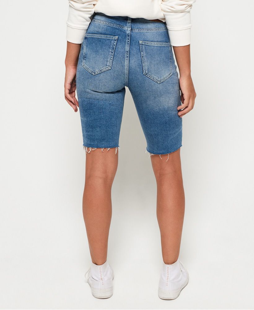Superdry women's Kari longline shorts. These shorts feature a distressed hem, a zip and button fly fastening and a classic five pocket design. Finished with a Superdry logo badge on the coin pocket and a leather Superdry logo patch on the rear waistband.