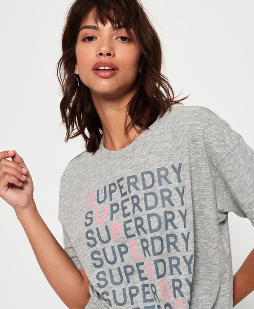 Superdry women's Sunday graphic t-shirt. This soft touch t-shirt features a crew neck, knotted front and large logo design across the front. Completed with a logo tab on the hem, this t-shirt is the perfect partner to skinny jeans or joggers this season.