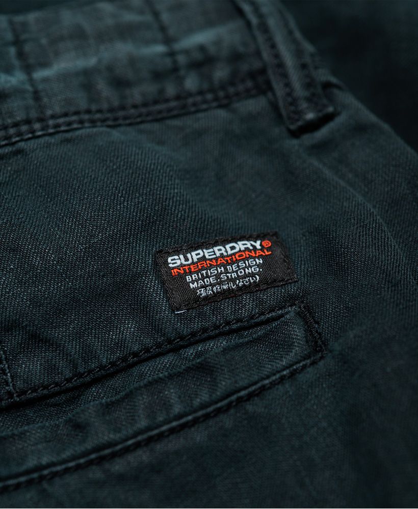Superdry men's International Linen Chino shorts. Classic design shorts and classic chino twill fabric, but made from linen instead. Lightweight and cool to the touch, these shorts are ideal for the warmer weather when comfort is key. Featuring a zip fly fastening, five pocket design and belt loops. Completed with a logo tab on one front pocket and small logo badge above the back pocket, pair with a crisp, short sleeve shirt for a smart, yet casual look.