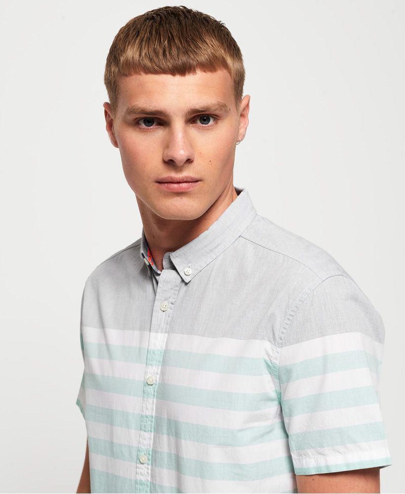 Superdry men's International Poplin short sleeve shirt. This classic button down shirt features short sleeves, a curved hem and logo badge on the placket. Completed with a logo badge on the side seam, pair with chinos and trainers for a smart yet casual look.
